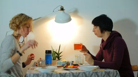 Two lesbians are sitting at the table having breakfast. Stock Footage 122748564