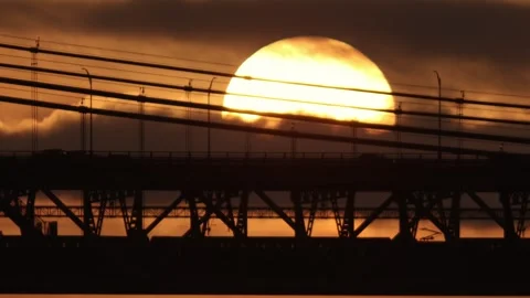 A two-level bridge for electric trains and cars at sunset - a huge bright sun Stock Footage 255042601