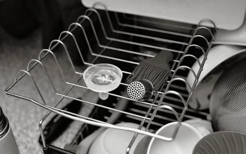Two level dish rack in black and white with some clean dishes and a baby bott Stock Photos