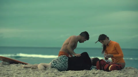 Two Lifeguards performing CPR on the beach Stock Footage 263931274