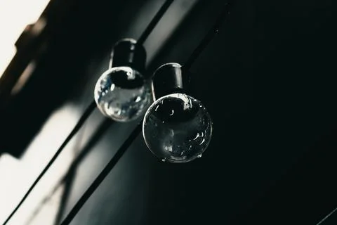 Two light bulbs on black background Stock Photos