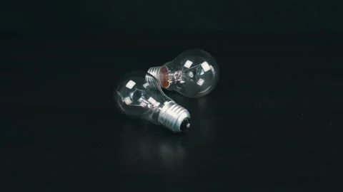 Two light bulbs on black table Stock Footage 105745232
