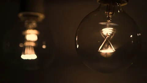 Two light bulbs in the dark light up and go out. Tesla light bulb. Stock Footage 223921842