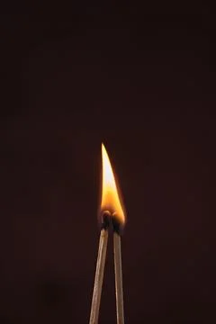 Two lighted matches on a dark background Foto stock