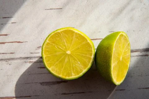 Two lime halves close-up, copy space, pattern, rough shadows Foto stock