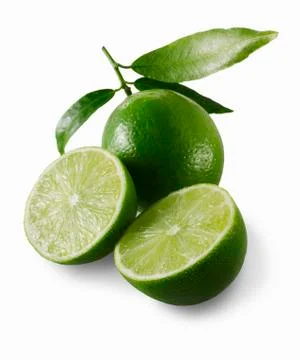 Two lime halves in front of a whole lime Foto stock