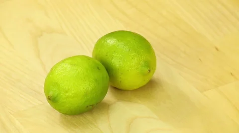 Two lime rotate on the background of wooden boards Stock Footage 42916117