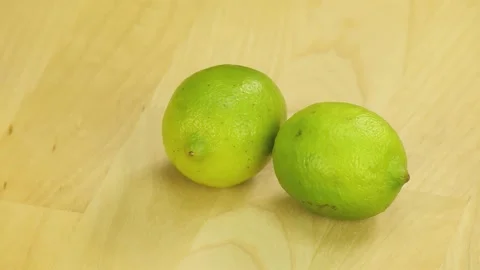 Two lime rotate on the background of wooden boards	 Stock Footage 181966454