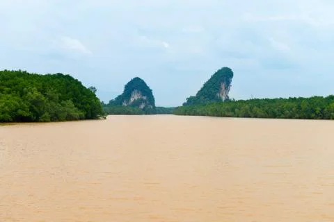 Two limestone cliffs above tropical river and mangrove Stock Photos
