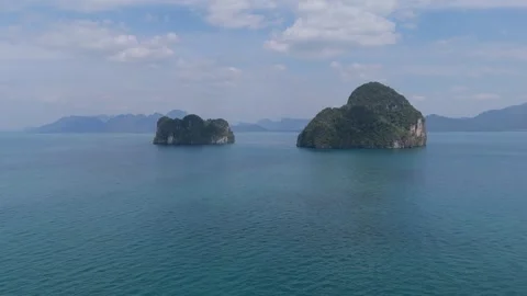 Two limestone islands in turquoise sea under cloudy sky in Thailand Vídeos de archivo 333864864