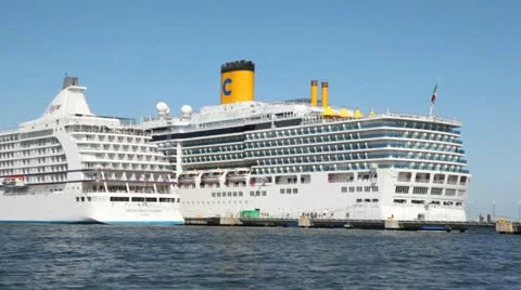Two liners Costa Luminosa and Seven Seas Voyager stand on port Stock Footage