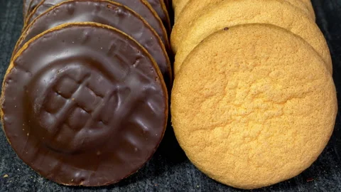 Two lines of biscuits, made from soft cake with dark chocolate coating. Video stock 221253840