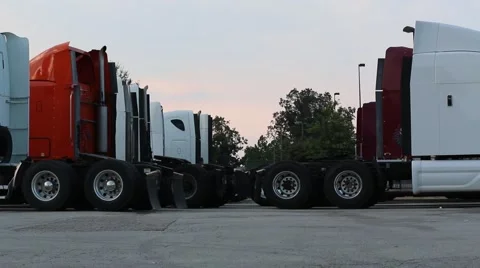 Two Lines of Multi-Colored Big Rig Tractors Parked at Truck Stop Stock Footage 54417656