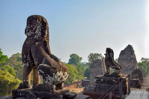 Two lion statues looking over jungle in angkor wat temple ruins, cambodia Stock Photos