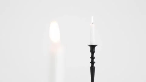 Two lit white candles sharing space on a white background Stock Footage 195999143