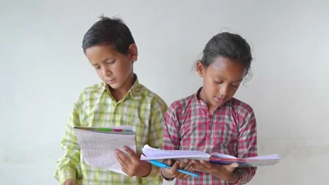 Two little adorable primary school children holding books &amp; reading in classroom Stock Footage 161813646