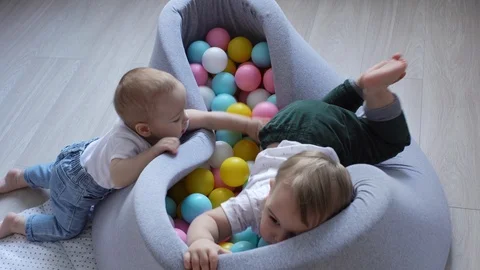 Two little boys are trying to get into the pool with plastic balls Stock Footage 103701020