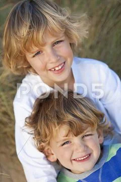 Two little boys, brothers, together on a sunny beach Stock Photos