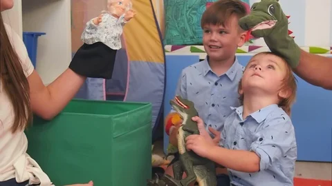 Two little boys having fun playing with hand puppets Видео 76561559