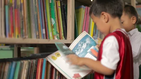 Two little boys in the library of their school in the Philippines Stock Footage