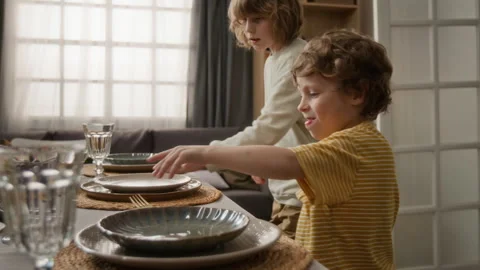 Two Little Brothers Setting Dining Table for Family Dinner Stock Footage 340332466