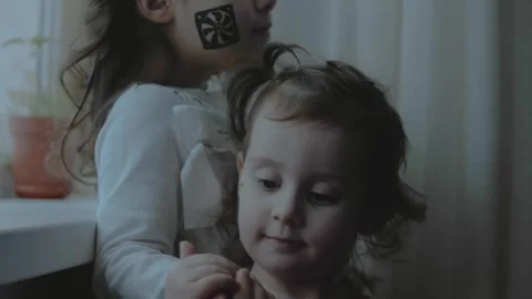 Two little girls with computer components paintings on their faces. Pointing Stock Footage 258397387