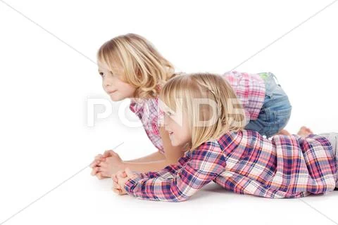 Two little girls lying on the floor Stock Photos