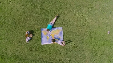 Two little girls playing with map in the park 스톡 동영상 76597295