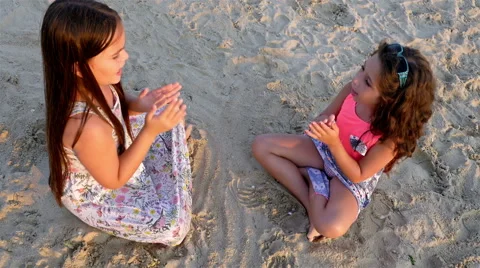 Two little girls playing on the sea beach Stock Footage