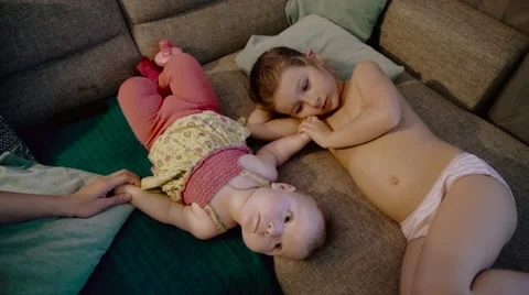Two little girls playing on the sofa Stock Footage
