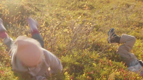 Two little girls rolling down a hill. Russia, Teriberka Stock Footage 301723114
