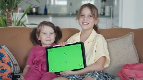 Two Little Sister are Using a Digital Tablet with Green Screen Stock Footage 248705708