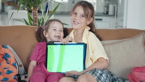 Two Little Sister are Using a Digital Tablet with Green Screen Stock Footage 248768159