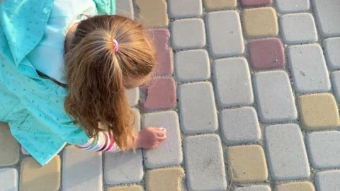 Two little sisters draw crayons on the pavement Stock Footage 153490318