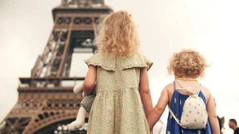 Two little sisters hold hands and look at the Eiffel Tower in Paris, France Stock Footage 246369305