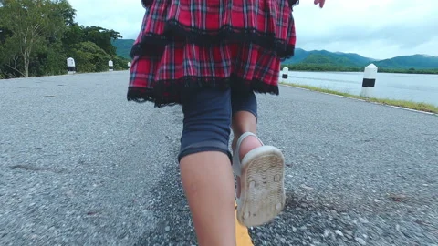 Two little sisters running forward along the lakeside road at sunset. Childhood  Stock Footage 163648710