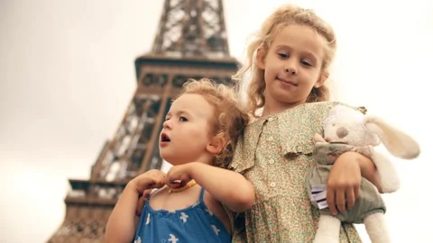 Two little sisters stand at the Eiffel Tower in Paris, France Stock Footage 246477455