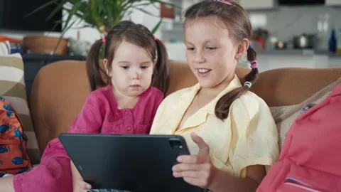 Two little sisters use digital tablet computer Stock Footage 255574610