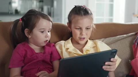Two little sisters use digital tablet computer Stock Footage 256815823