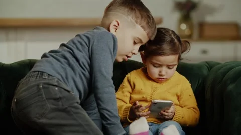Two little toddler using online parental control app on mobile phone, playing Stock Footage 243366496