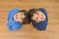 The two little twin smile to the camera. View from above Photo