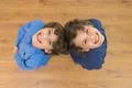 The two little twin smile to the camera. View from above Photo