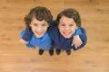 The two little twin smile to the camera. View from above Photo
