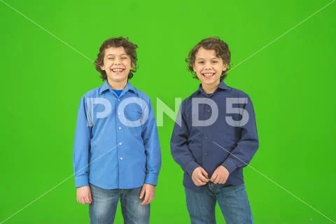 The two little twin stand on the green background Stock Photos