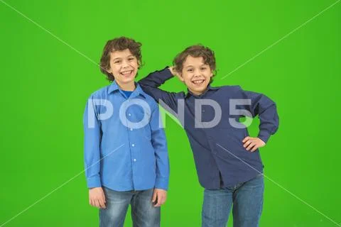 The two little twin stand on the green background Stock Photos