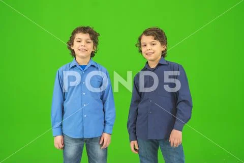 The two little twin stand on the green background Stock Photos