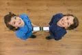 The two little twin stand with a phone. View from above Photo