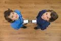 The two little twin stand with a phone. View from above Photo