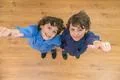 The two little twin thumb up to the camera. View from above Photo