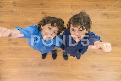 The two little twin thumb up to the camera. View from above Stock Photos